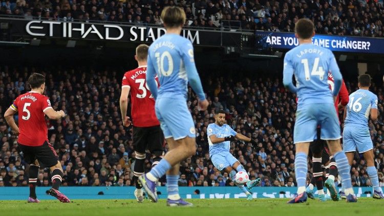 Riyad Mahrez melepaskan tembakan yang berbuah gol ketiga untuk Manchester City atas Manchester United (06/03/22). (Foto: Reuters/Carl Recine) Copyright: © Reuters/Carl Recine