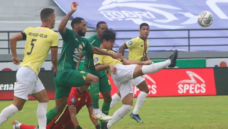 Bek Persik Kediri, Risna Prahala Benta menyapu bola yang hendak direbut pemain Persebaya Surabaya dalam laga BRI Liga 1 2021/2022, Kamis (10/03/22). Copyright: © Nofik Lukman Hakim/INDOSPORT