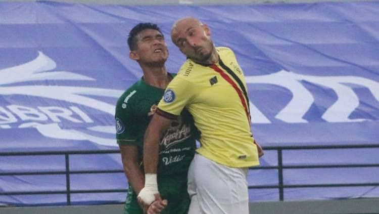 Penyerang Persik Kediri, Youssef Ezzejjari memenangi duel udara dengan bek Persebaya, Rizky Ridho, dalam lanjutan Liga 1. Copyright: © Nofik Lukman Hakim/INDOSPORT