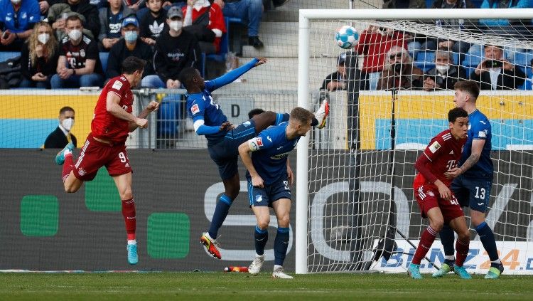 Robert Lewandowski melepaskan tandukan yang berbuah gol di laga Hoffenheim vs Bayern Munchen (12/03/22). (Foto: REUTERS/Heiko Becker) Copyright: © REUTERS/Heiko Becker