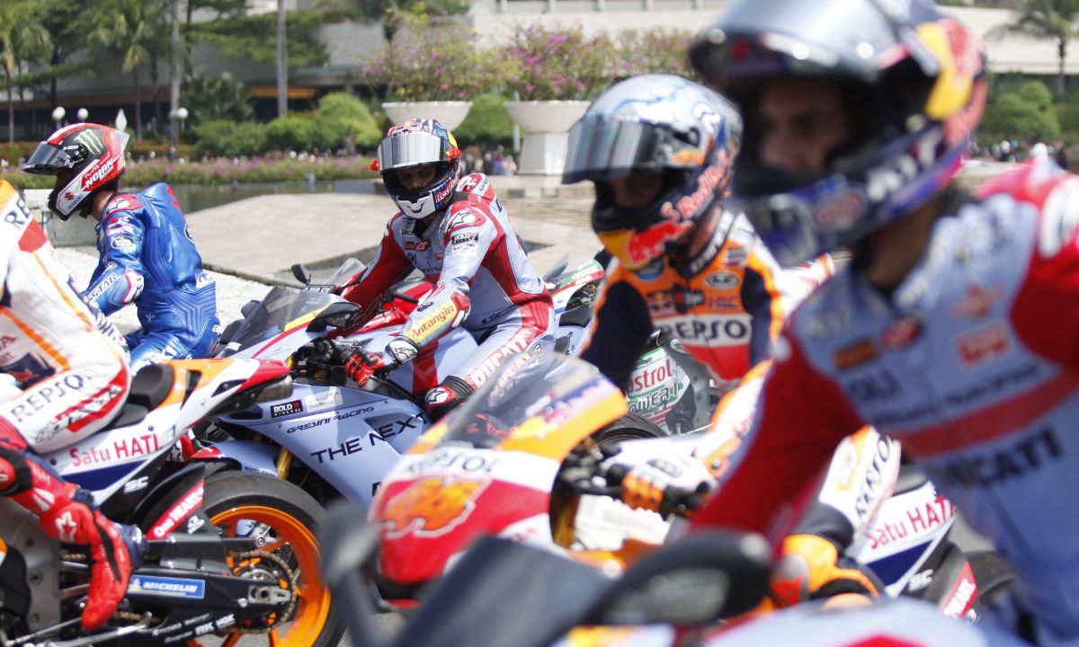 Pembalap Honda, Marc Marquez, menunjukkan aksi tengilnya di tengah jalanan ibukota Jakarta selama parade MotoGP jelang balapan di Sirkuit Mandalika. Copyright: © Herry Ibrahim/INDOSPORT