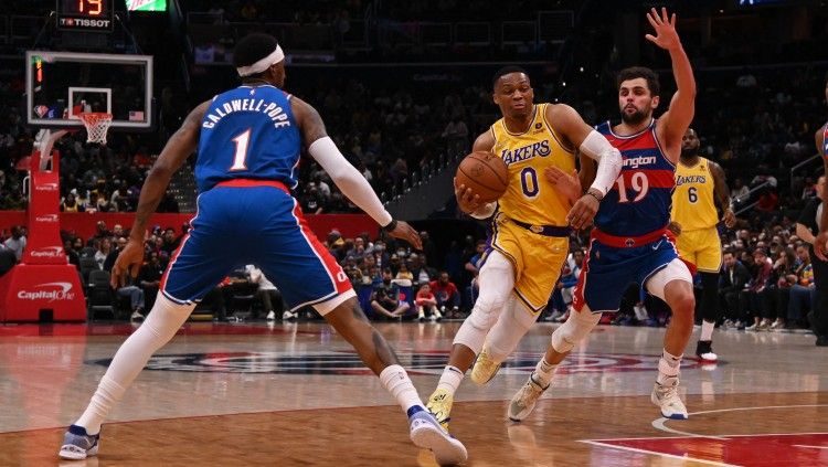 Russell Westbrook (tengah) mencoba melewati hadangan Raul Neto (kanan) di laga Washington Wizards vs Los Angeles Lakers (Foto: Reuters/Tommy Gilligan-USA TODAY Sports) Copyright: © Reuters/Tommy Gilligan-USA TODAY Sports