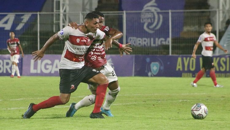 Perebutan bola gelandang Bali United, Eber Bessa dengan bek Madura United, Jaimerson Xavier. Foto : Nofik Lukman Hakim/INDOSPORT Copyright: © Nofik Lukman Hakim/INDOSPORT