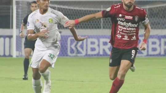 Penyerang Bali United, Ilija Spasojevic dikawal ketat bek Persebaya Surabaya, Rizky Ridho. Foto; Nofik Lukman Hakim/INDOSPORT Copyright: © Nofik Lukman Hakim/INDOSPORT