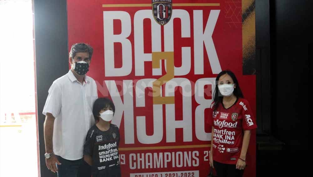 Pelatih Bali United, Stefano Cugurra Teco bersama istri dan anaknya berpose di papan Back2Back. Foto; Nofik Lukman Hakim/Indosport.com Copyright: © Nofik Lukman Hakim/Indosport.com