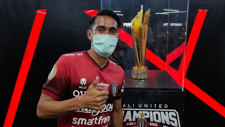 Muhammad Sidik Saimima saat berpose dengan replika piala juara Liga 1 di Bali United Megastore. Foto: Nofik Lukman Hakim/INDOSPORT Copyright: © Nofik Lukman Hakim/INDOSPORT