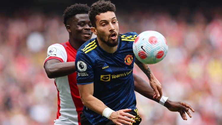 Alex Telles berebut bola dengan Bukayo Saka di laga Arsenal vs Man United (23/04/22). (Foto: REUTERS/David Klein) Copyright: © REUTERS/David Klein