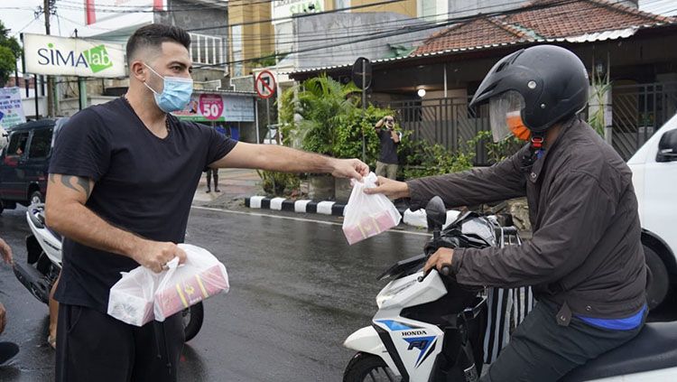 Pelatih Persik Kediri, Javier Roca, saat membagikan takjil di pinggir jalan kepada warga Kediri. Copyright: © MO Persik