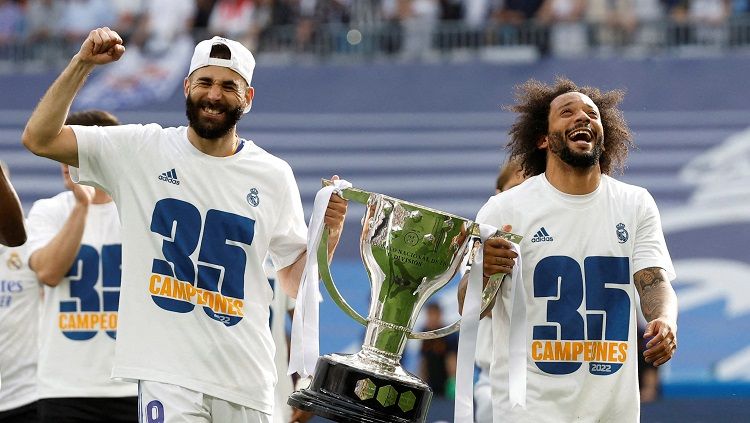 Karim Benzema dan Marcelo merayakan kesuksesan Real Madrid menjuarai Liga Spanyol 2021/2022 (REUTERS/Juan Medina) Copyright: © REUTERS/Juan Medina