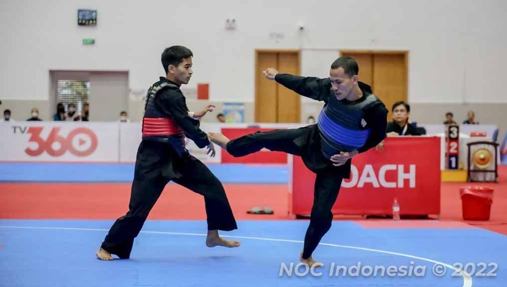 Pesilat Indonesia Khoirudin Mustakim (biru) berjuang mengalahkan lawannya Muhammad Khairi Adib asal Malaysia di final tarung kelas 50-55kg di SEA Games 2021 Vietnam. Foto: NOC Indonesia/MP Media/Evan Andraws Copyright: © NOC Indonesia/MP Media/Evan Andraws