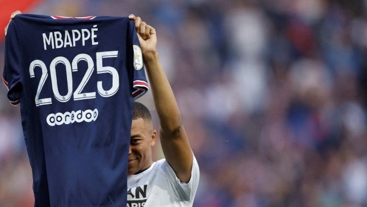 Kylian Mbappe menunjukkan jersey PSG setelah menandatangani kontrak pada 2022 lalu yang membuatnya bisa tetap di Paris hingga 2025. Copyright: © REUTERS/Christian Hartmann