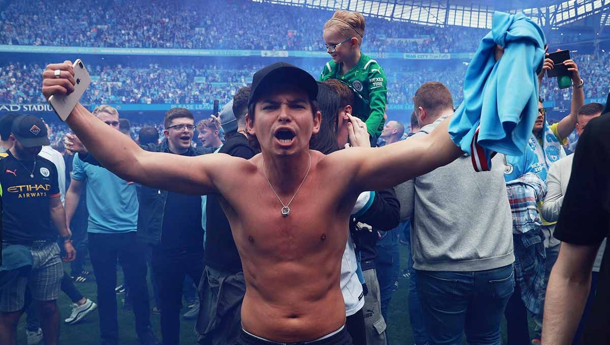 Fans Manchester City merayakan di lapangan setelah timnya menjuarai Liga Inggris 2021/2022. Foto: REUTERS/Hannah Mckay Copyright: © REUTERS/Hannah Mckay