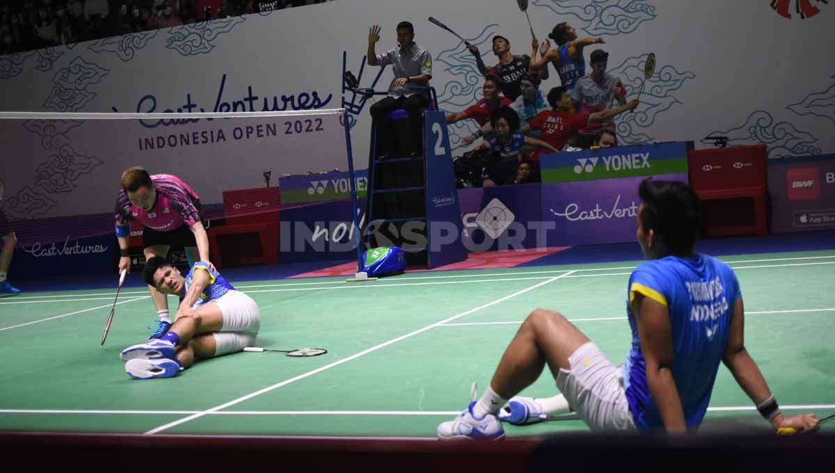 Pasangan ganda putra Indonesia, Yeremia Rambitan saat mengalami cedera lutut di Indonesia Open 2022. Foto: Herry Ibrahim/INDOSPORT Copyright: © Herry Ibrahim/INDOSPORT