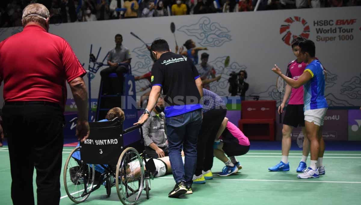 Pasangan ganda putra Indonesia, Yeremia Rambitan saat mengalami cedera lutut di Indonesia Open 2022. Foto: Herry Ibrahim/INDOSPORT Copyright: © Herry Ibrahim/INDOSPORT
