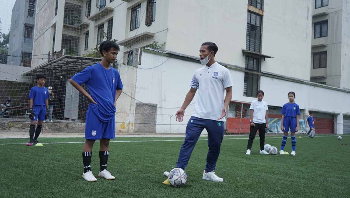 Indosport - Pemain Persib berbagai ilmu sepakbola dengan Bobotoh cilik di Lapangan Soccer Republic, Kota Bandung, Minggu (26/06/22). Foto: Media officer Persib
