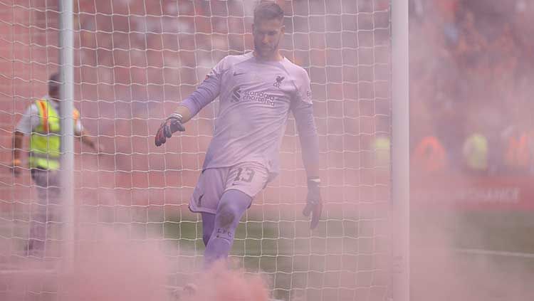 Kiper Liverpool, Adrian, mencoba menyingkiran flare yang dilempar suporter di laga melawan Manchester City dalam ajang Community Shield, Sabtu (30/07/22). Copyright: © Reuters/Andrew Boyers