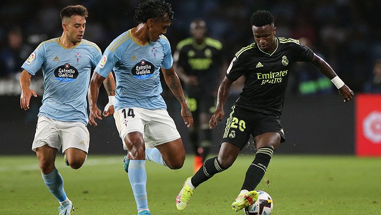 Pemain Real Madrid, Vinicius Jr saat berusaha mempertahankan bola dari rebutan pemain Celta Vigo di Liga Spanyol. Copyright: © REUTERS/Isabel Infantes