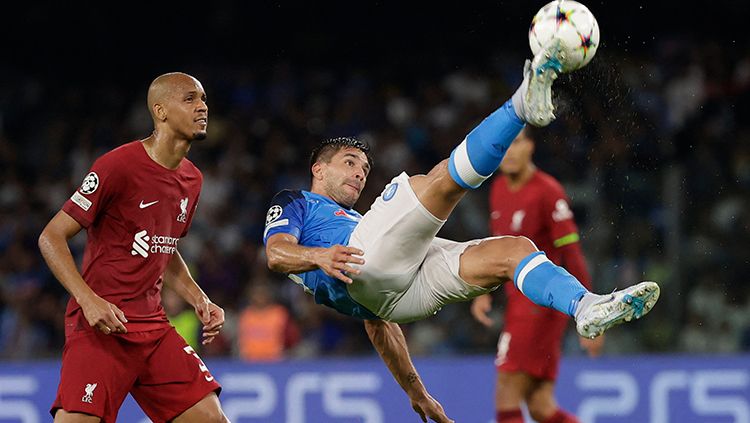 Aksi akrobatik pemain Napoli, Giovanni Simeone, saat melawan Liverpool di Liga Champions. Copyright: © REUTERS/Ciro De Luca