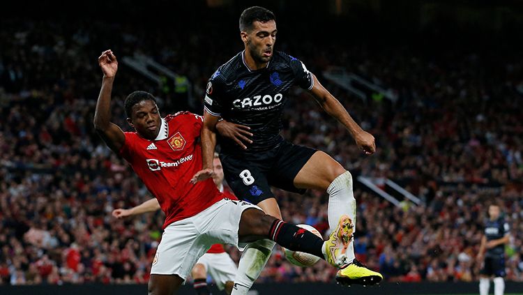 Pemain Real Sociedad saat menerima bola tapi diganggu pemain Manchester United. Copyright: © REUTERS/Craig Brough