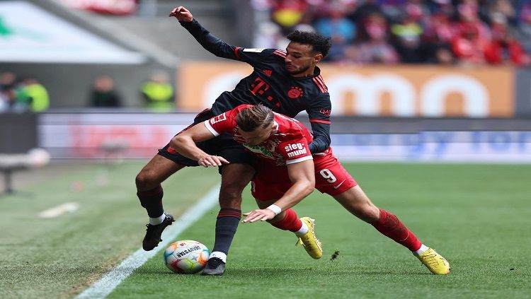 Pemain Bayern Munchen, Noussair Mazraoui berduel dengan bomber Augsburg, Ermedin Demirovic REUTERS/Lukas Barth Copyright: © reutersconnect.com