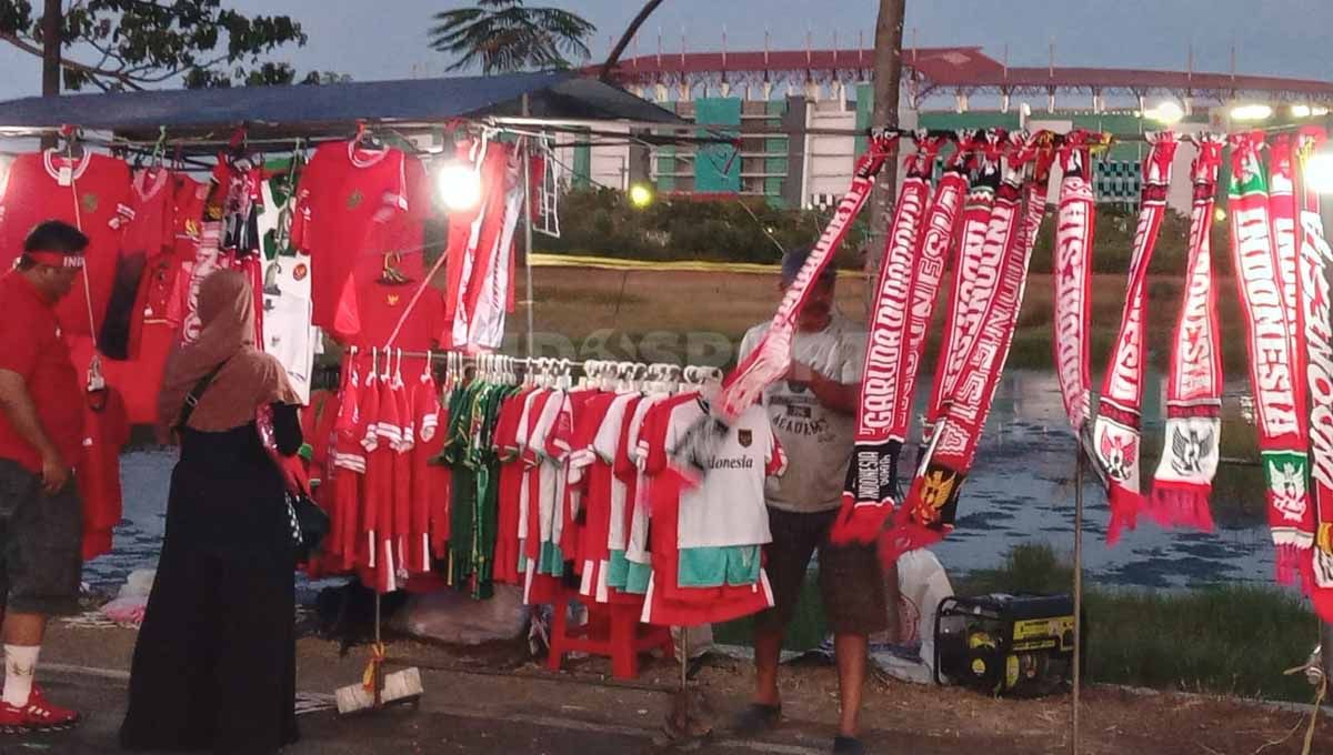 Pedagang penjual syal beratribut Timnas Indonesia dijual berjejer di Stadion GBT. Copyright: © Ian Setiawan/INDOSPORT