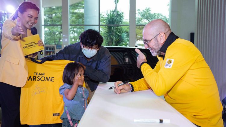 Legenda sepak bola dan brand ambassador CARSOME, Eric Cantona (kanan) memberikan tanda tangan di merchandise edisi terbatas CARSOME x Cantona dan berfoto bersama mitra CARSOME (kiri) dalam acara Special Meet and Greet. Copyright: © Humas CARSOME