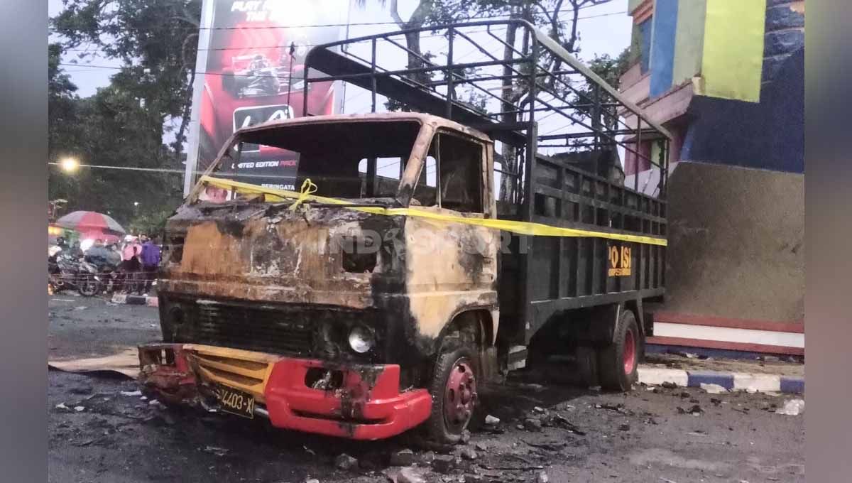 Truk kepolisian yang dibakar pasca kerusuhan suporter. Copyright: © Ian Setiawan/INDOSPORT