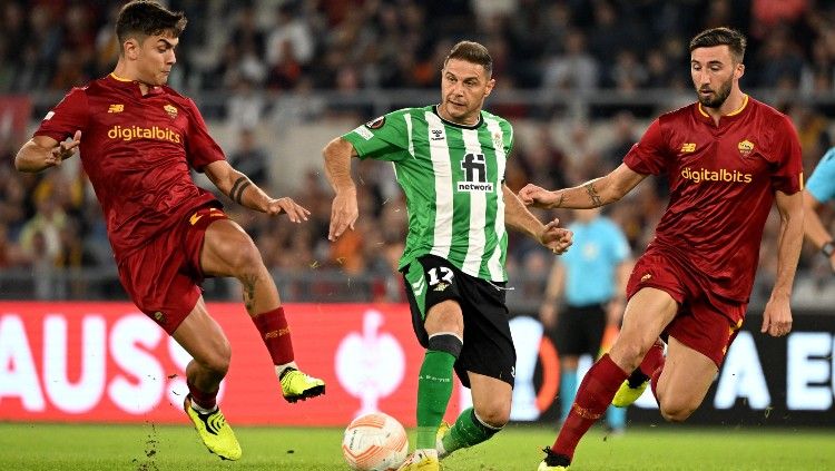 Paulo Dybala (kiri) dan Joaquin (tengah) berduel di laga AS Roma vs Real Betis. (Foto: REUTERS/Alberto Lingria) Copyright: © REUTERS/Alberto Lingria