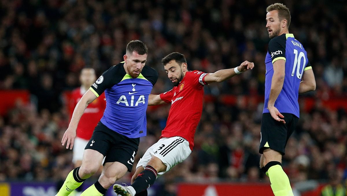 Duel antara Bruno Fernandes dengan Pierre-Emile Hojbjerg dan Harry Kane dalam laga Liga Inggris antara Manchester United vs Tottenham Hotspur Copyright: © Reuters/Craig Brough