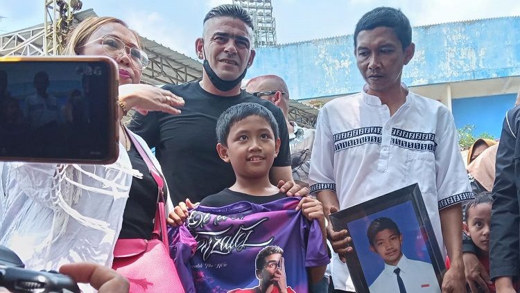 Cristian Gonzales saat memberi kaos untuk adik korban Tragedi Kanjuruhan. Copyright: © Ian Setiawan/INDOSPORT