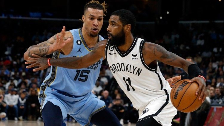 Kyrie Irving (kanan), mencoba melewat Brandon Clark di laga NBA Memphis Grizzlies vs Brooklyn Nets (25/10/22). (Foto: Reuters/Petre Thomas-USA TODAY Sports) Copyright: © Reuters/Petre Thomas-USA TODAY Sports