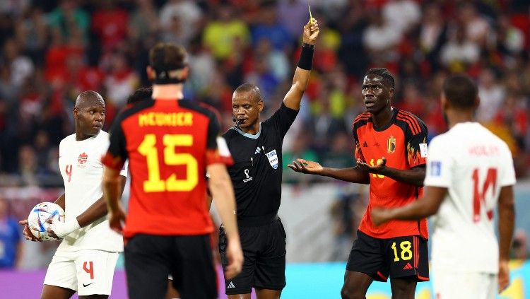 Wasit asal Zambia, Janny Sikazwe, saat memberi kartu kuning ke Amadou Onana di laga Piala Dunia 2022 Belgia vs Kanada (24/11/22). (Foto: REUTERS/Siphiwe Sibeko). Copyright: © REUTERS/Siphiwe Sibeko