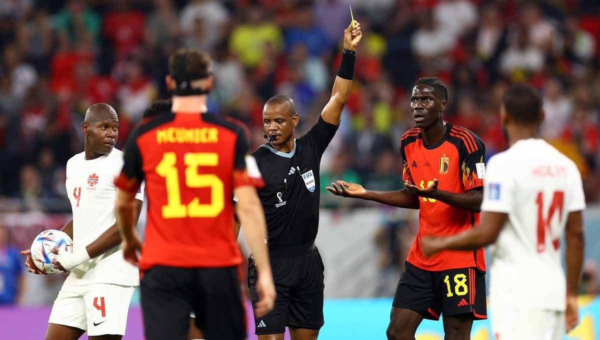 Pemain Belgia Amadou Onana mendapat kartu kuning dari wasit Janny Sikazwe di grup F Piala Dunia Qatar 2022. (Foto: REUTERS/Siphiwe Sibeko) Copyright: © REUTERS/Siphiwe Sibeko