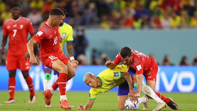 Dua pemain Swiss, Granit Xhaka (kiri) dan Remo Freuler menutup ketat penyerang Brasil, Richarlison dalam pertandingan kedua Grup G Piala Dunia 2022  (Foto: REUTERS/Hannah Mckay). Copyright: © REUTERS/Hannah Mckay