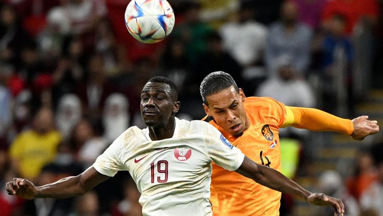 Duel udara antara bek Belanda, Virgil van Dijk (kanan) dengan striker Qatar, Almoez Ali dalam laga terakhir Grup A Piala Dunia 2022 (Foto: REUTERS/Alberto Lingria). Copyright: © REUTERS/Alberto Lingria