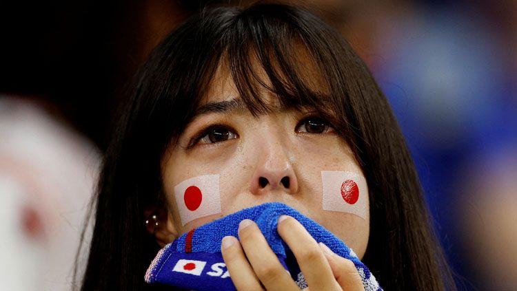 Seorang fans Jepang tak kuasa menahan tangis saat negaranya kalah dari Kroasia di babak 16 besar Piala Dunia 2022 (Foto: REUTERS/John Sibley). Copyright: © REUTERS/John Sibley