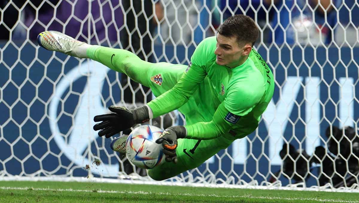 Kiper Kroasia Dominik Livakovic saat menyelamatkan tendangan penalti yang gagal dilakukan Takumi Minamino pemain Jepang. (Foto: REUTERS/Marko Djurica) Copyright: © REUTERS/Marko Djurica