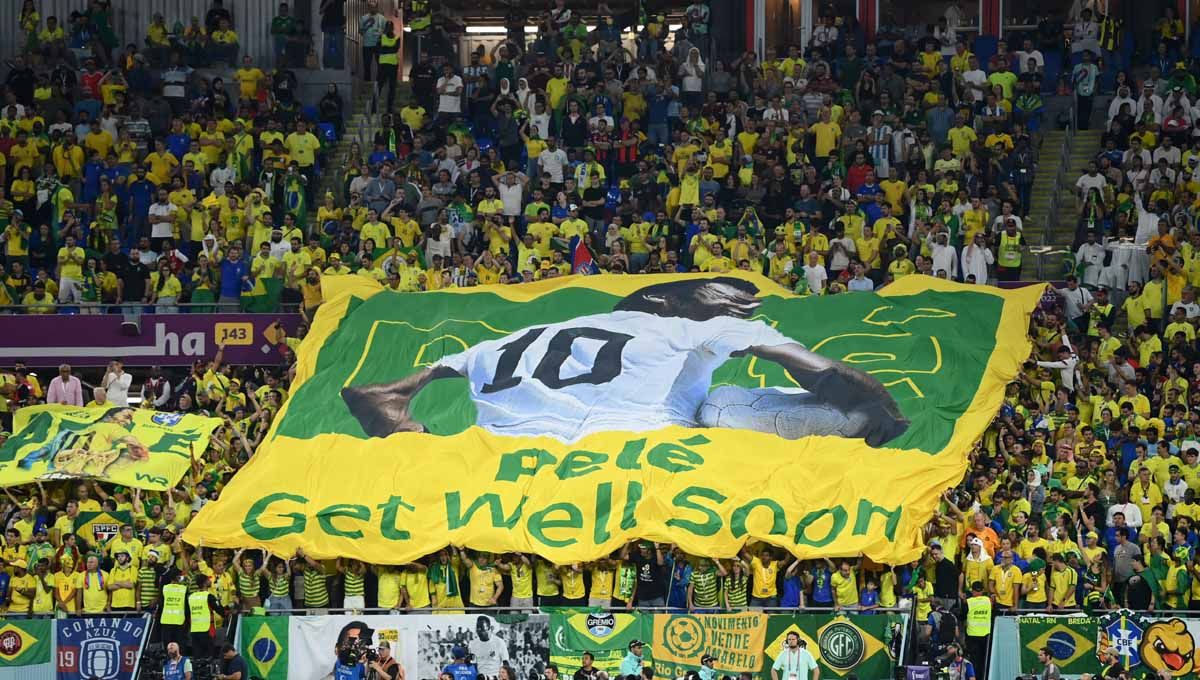 Aksi Fans Brasil mengangkat spanduk mantan pemain Brasil Pele dengan pesan semoga cepat sembuh. (Foto: REUTERS/Annegret Hilse) Copyright: © REUTERS/Annegret Hilse