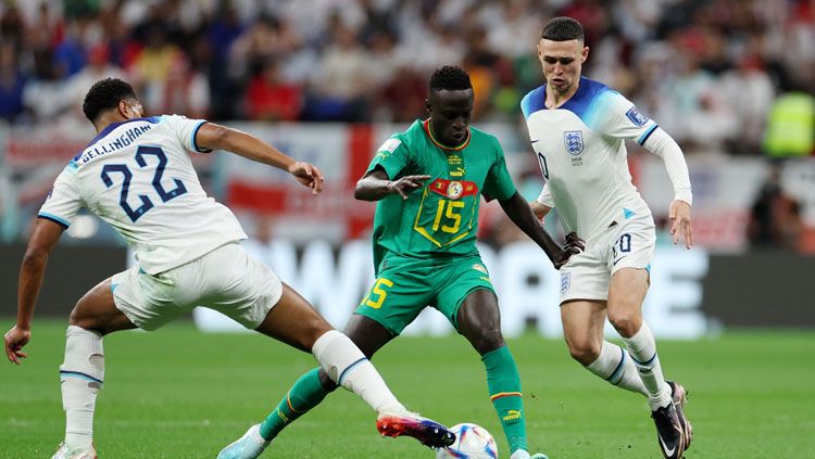 Dua penggawa Timnas Inggris, Jude Bellingham (kiri/22) dan Phil Foden (kanan) menutup pergerakkan pemain Senegal, Krepin Diatta di pertandingan babak 16 besar Piala Dunia 2022 (Foto: REUTERS/Marko Djurica). Copyright: © REUTERS/Marko Djurica