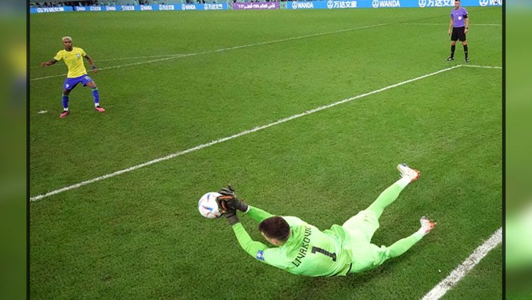 Kiper Timnas Kroasia, Dominik Livakovic saat menepis tendangan penalti dari pemain Brasil, Rodrygo di Babak Perempatfinal Piala Dunia 2022 (Foto: REUTERS/Matthew Childs). Copyright: © REUTERS/Matthew Childs