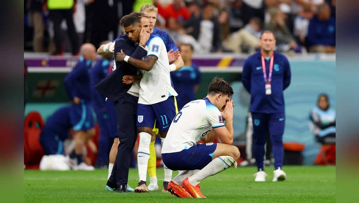 Harry Maguire terlihat sedih sementara Marcus Rashford dihibur oleh manajer Gareth Southgate usai pertandingan Inggris tersingkir dari Piala Dunia 2022. (Foto: REUTERS/Matthew Childs) Copyright: © REUTERS/Matthew Childs