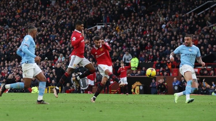 Bruno Fernandes melepaskan tembakan berbuah gol di laga Manchester United vs Manchester City (14/01/23). (Foto: REUTERS/Phil Noble) Copyright: © REUTERS/Phil Noble