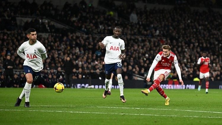 Martin Odegaard melepaskan tembakan berbuah gol di laga Liga Inggris 2022/23 Tottenham Hotspur vs Arsenal (Foto: REUTERS/Dylan Martinez) Copyright: © REUTERS/Dylan Martinez