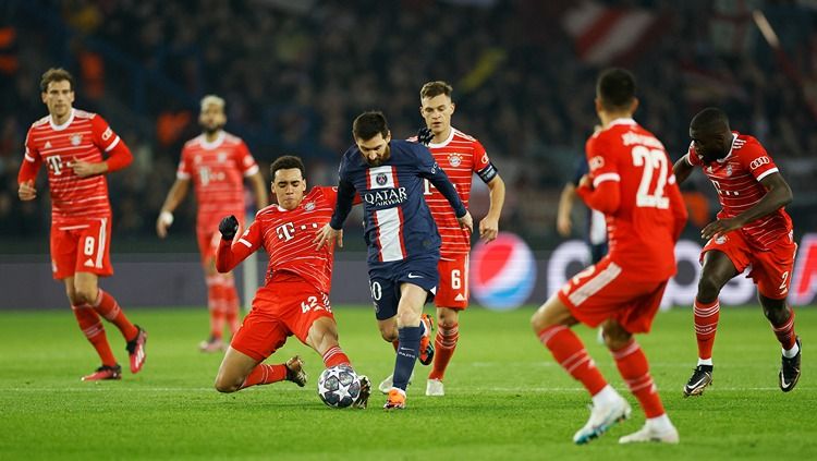 Lionel Messi berduel dengan Jamal Musiala di laga PSG vs Bayern Munchen (15/02/23). (Foto: REUTERS/Christian Hartmann) Copyright: © REUTERS/Christian Hartmann