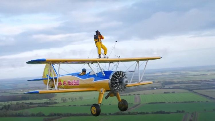 Youtuber yang terkenal dengan konten pendidikan, Jerome Polin berani melakukan extreme sports dengan berdiri di atas pesawat terbang si Inggris. Copyright: © YouTube Red Bull Indonesia