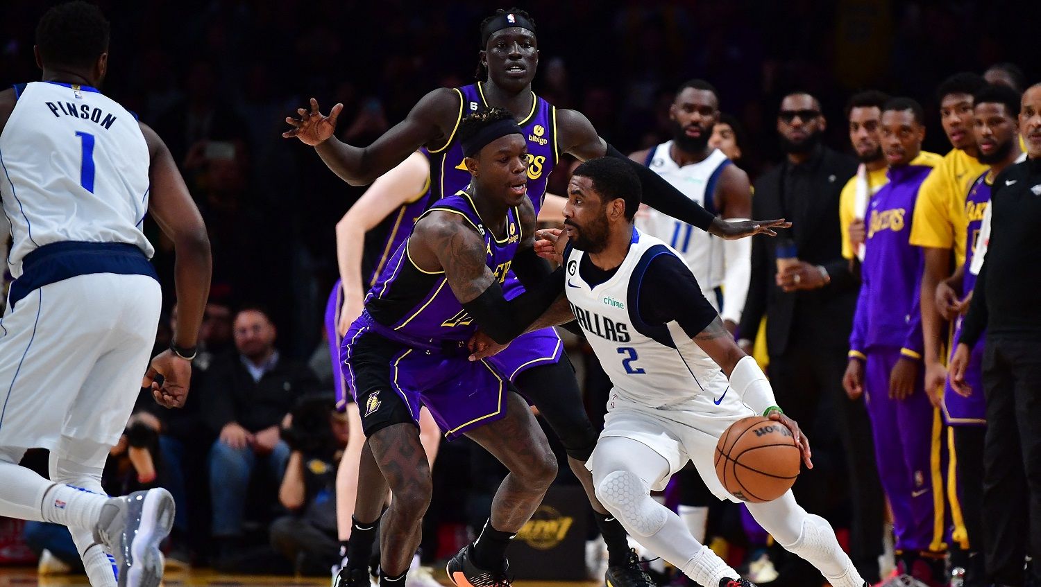 Guard Dallas Mavericks, Kyrie Irving, melewati pemain LA Lakers, Dennis Schroder, dalam laga NBA antara Dallas Mavericks vs LA Lakers, Sabtu (18/03/23) Copyright: © Gary A. Vasquez/REUTERS