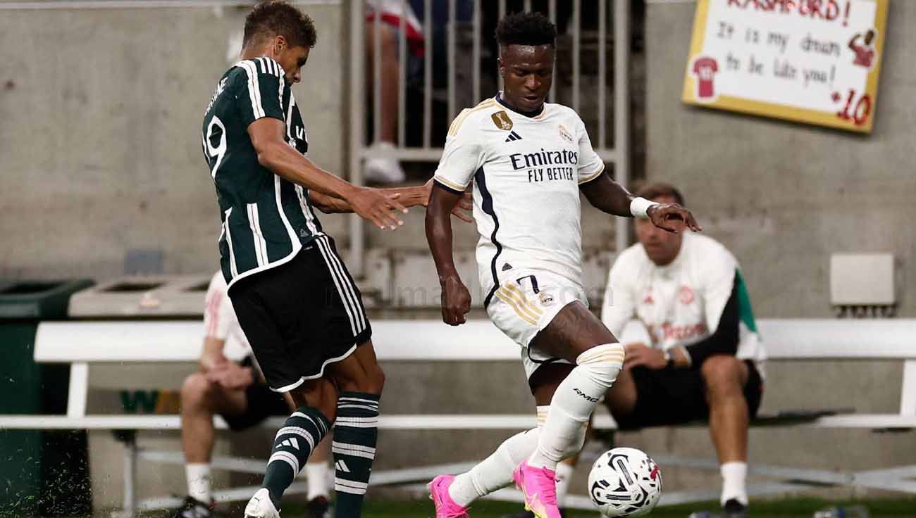 Pemain Real Madrid, Vinicius Junior ditempet ketat pemain Manchester United, Raphaël Varane di laga pramusim. (Foto: realmadrid) Copyright: © realmadrid