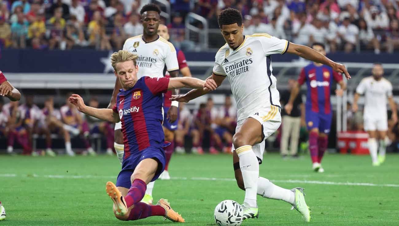 Gelandang Barcelona Frenkie de Jong mencoba merebut bola dari kaki gelandang Real Madrid Jude Bellingham. (Foto: REUTERS/Kevin Jairaj) Copyright: © REUTERS/Kevin Jairaj