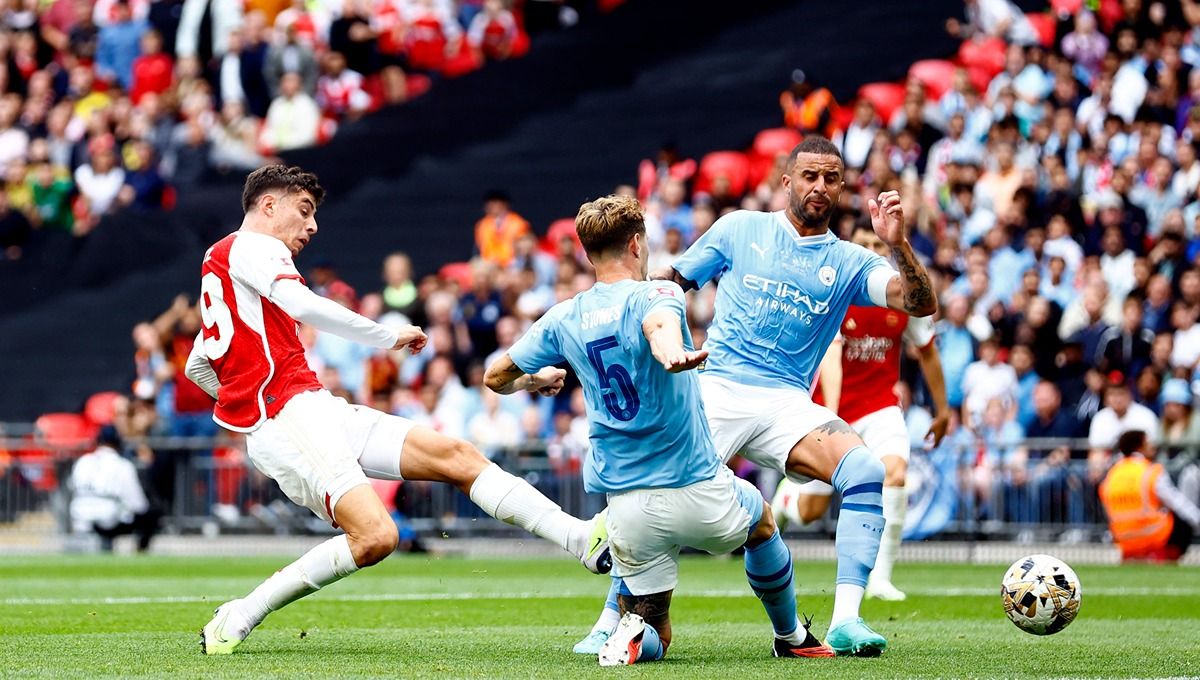 Kai Havertz berduel dengan Kyle Walker dan John Stones di laga Community Shield Manchester City vs Arsenal (06/08/23). (Foto: Reuters/Peter Cziborra) Copyright: © Reuters/Peter Cziborra