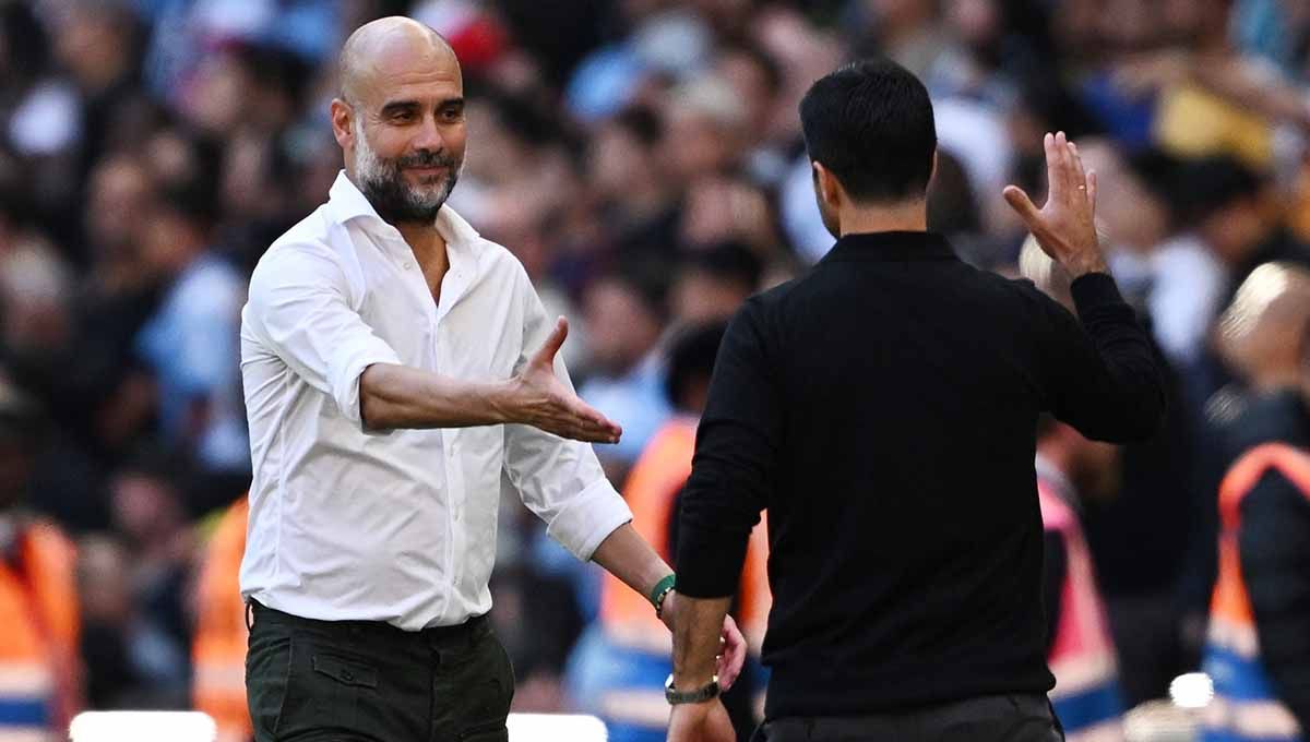 Pelatih Manchester City Pep Guardiola berjabat tangan dengan pelatih Arsenal Mikel Arteta usai pertandingan di laga Community Shield Manchester City vs Arsenal (06/08/23). (Foto: REUTERS/Dylan Martinez) Copyright: © REUTERS/Dylan Martinez